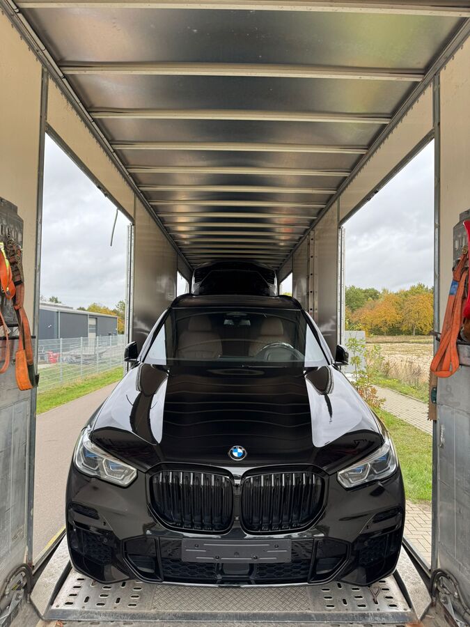 BMW X5 inside an enclosed car transporter