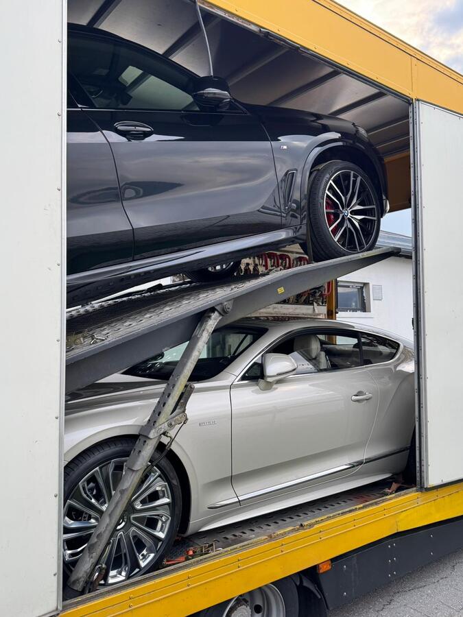 BMW X5 and Bentley Continental inside an enclosed car transporter