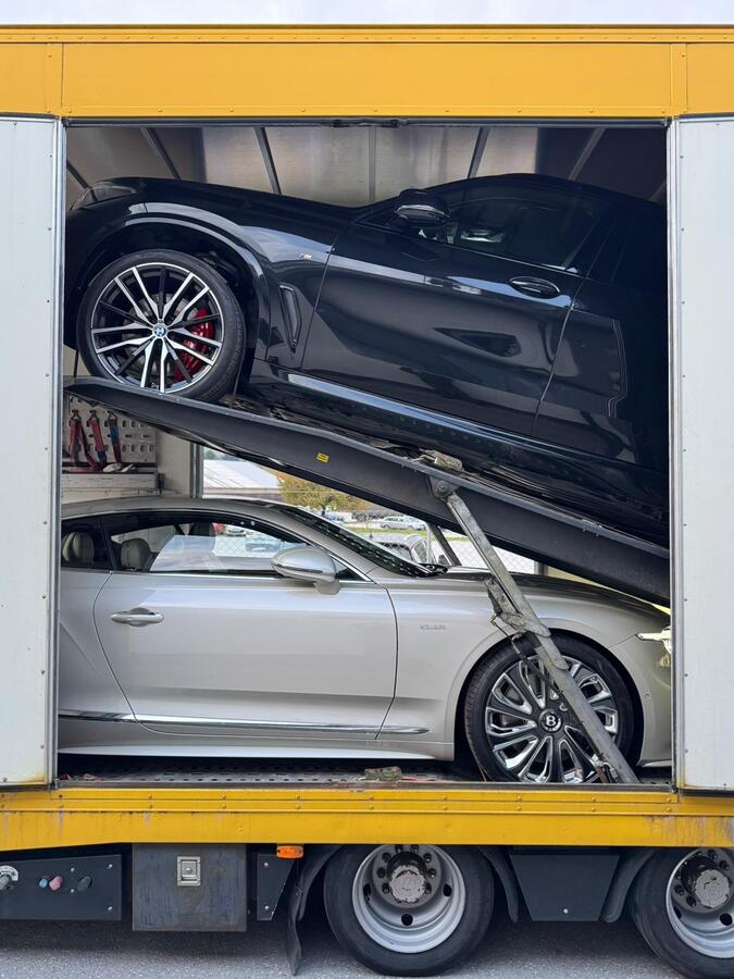 BMW X5 and Bentley Continental inside an enclosed car transporter