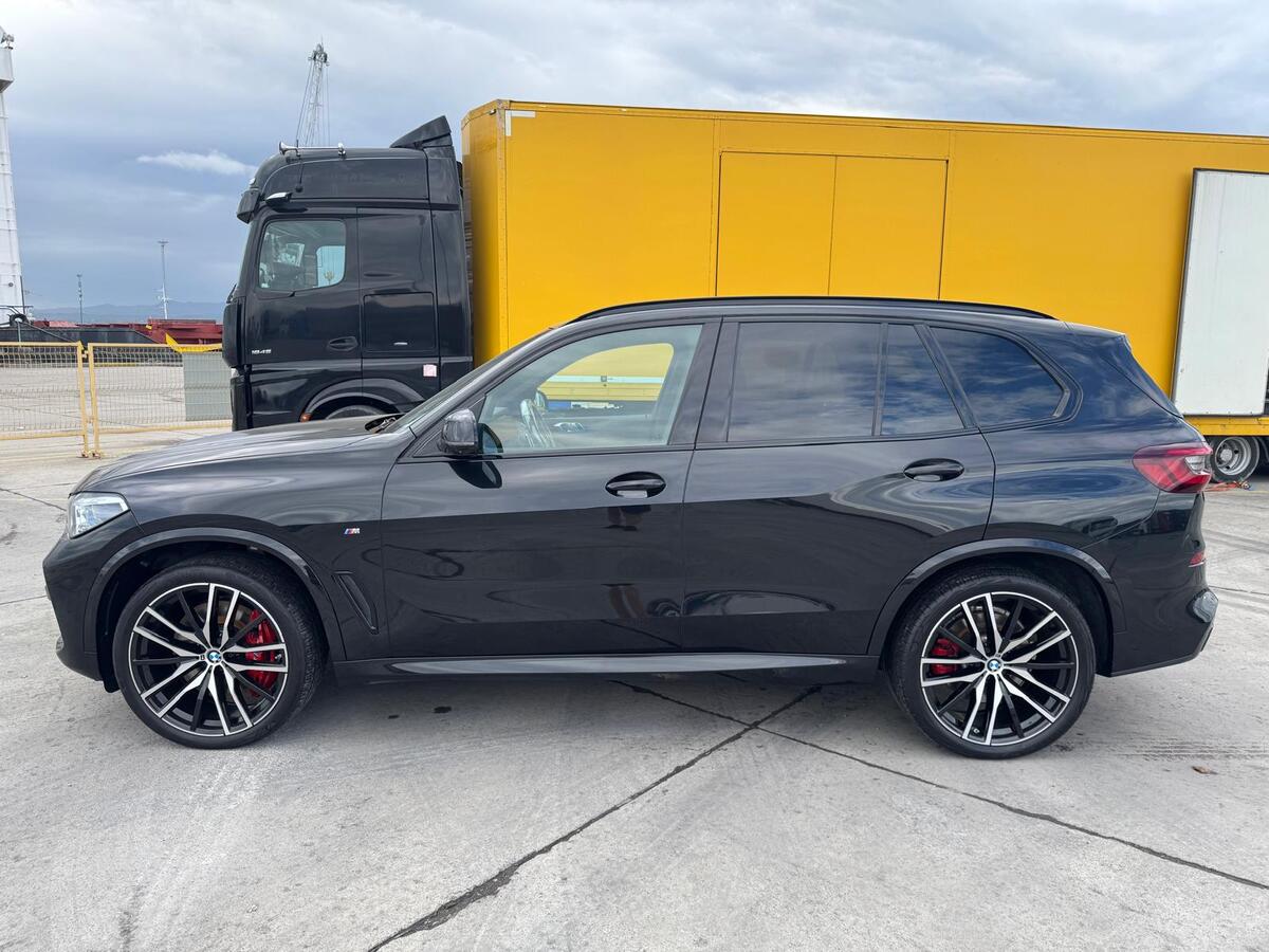 BMW X5 at the terminal beside an enclosed car transporter