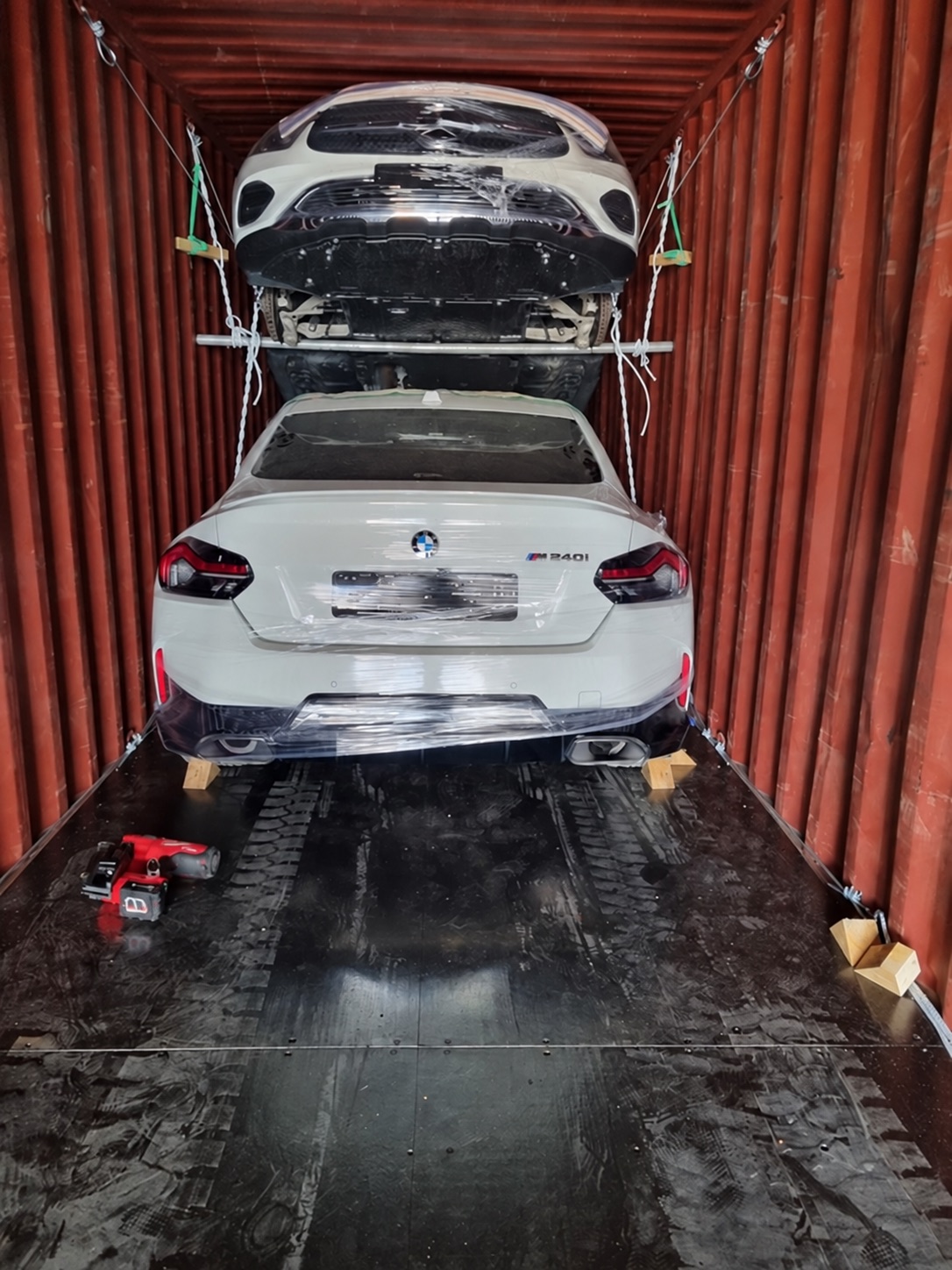 BMW M240 и другой автомобиль, закреплённые внутри контейнера.