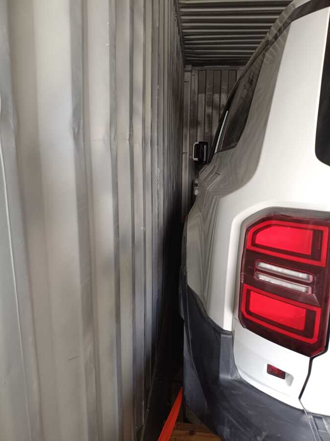 Odstęp między bokiem Toyoty Prado a ścianą kontenera.