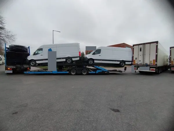 Sprinter vans on a car transporter beside the semitrailer involved in the incident