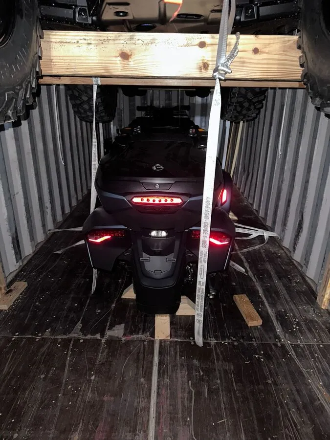 Can-Am Spyder roadster secured below the timber support structure inside the container.