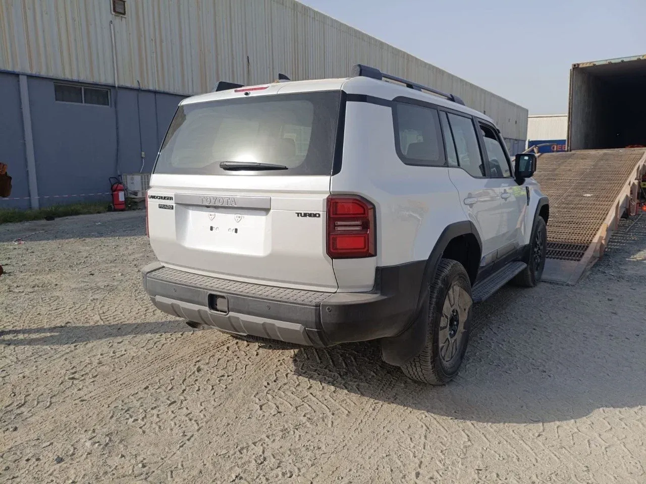 Toyota SUV in front of a loading ramp leading into a shipping container
